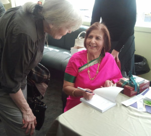 Shashi in sari signing a copy of her book